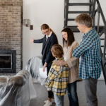 A family tours a new home with a real estate agent, discussing property details.